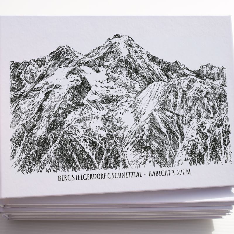 Hand holding a stack of postcards featuring a rocky mountain illustration
