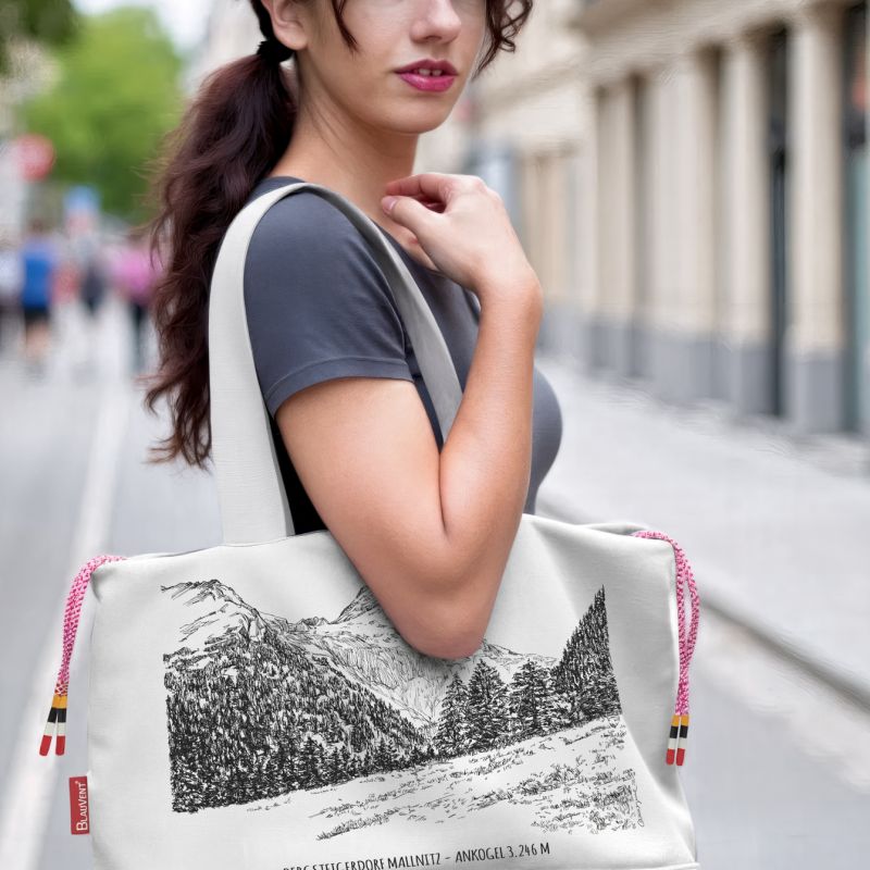 Woman carrying a white printed shoulder bag on a city street