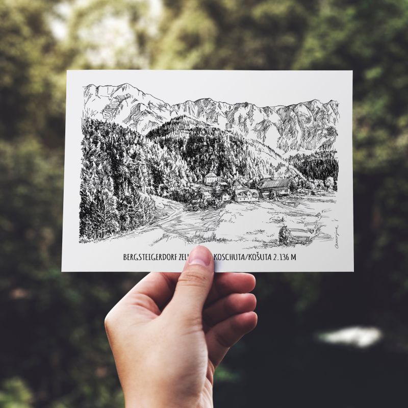 Hand holding an illustrated mountain postcard against a leafy background