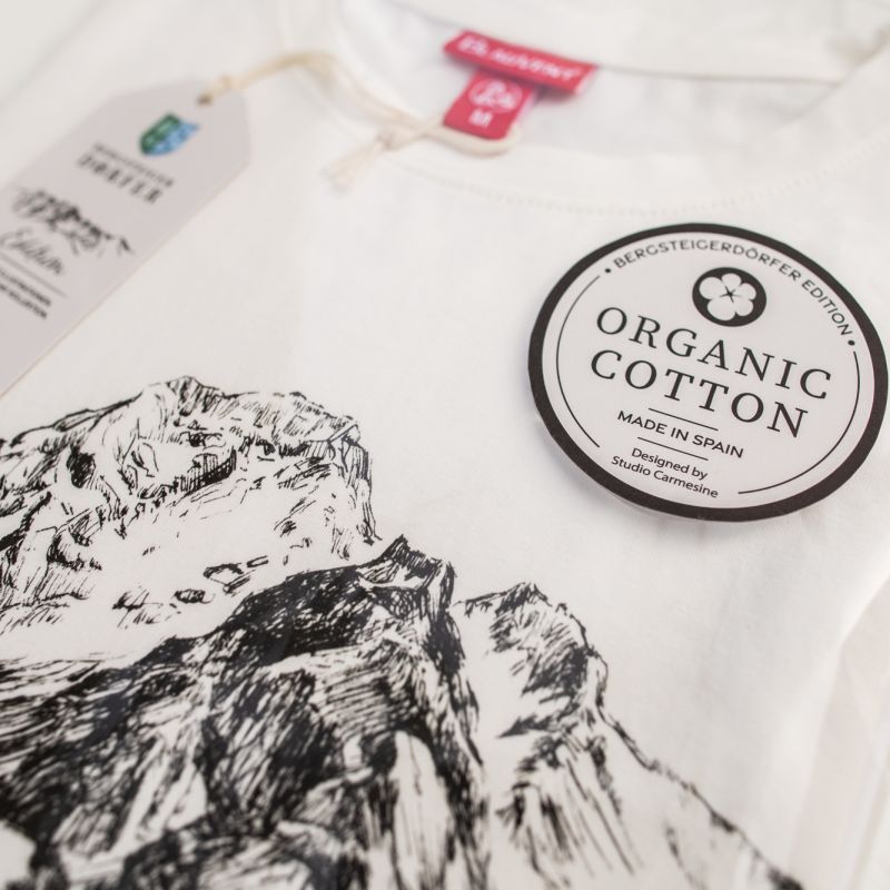Close-up of printed mountain T-shirt packaging with a cotton label
