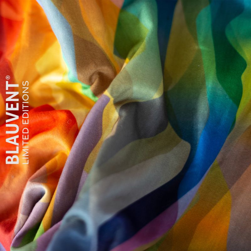 Macro fabric detail of a neckwarmer with colourful overlapping geometric shapes.